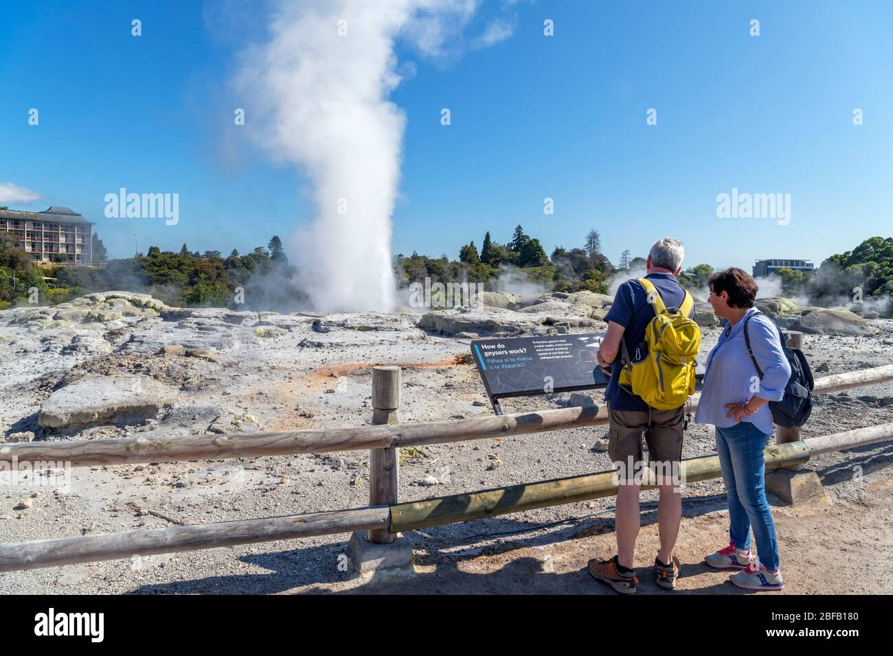 Rotorua, Nuova Zelanda. Coppia di fronte a Pōhutu Geyser, te Puia, te Whakarewarewa Geotermal Valley, Rotorua, Isola del Nord, Nuova Zelanda Foto Stock