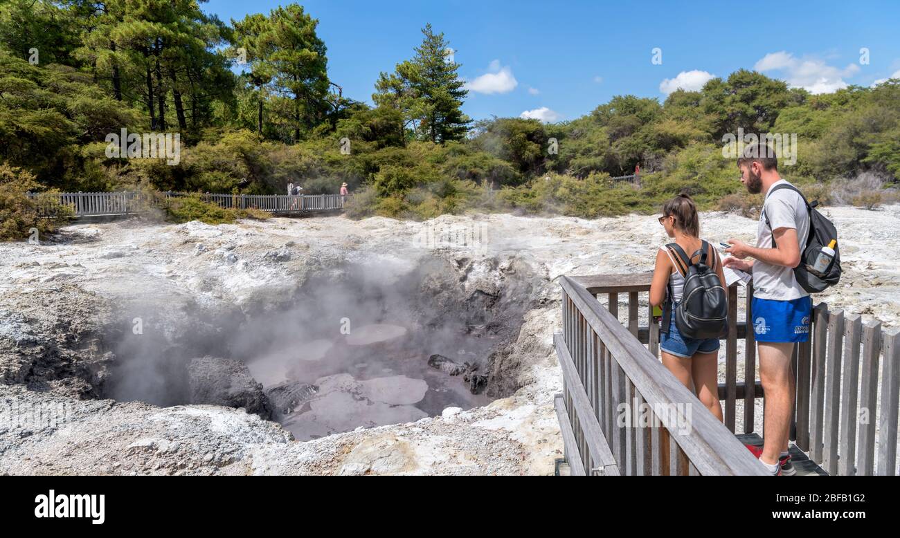 Visitatori presso una piscina di fango presso il Wai-o-Tapu Thermal Wonderland, vicino Rotorua, Nuova Zelanda Foto Stock