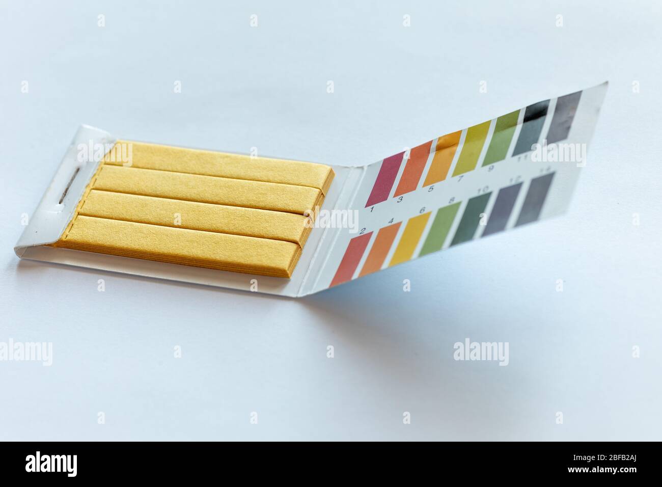 Test di pH universale Litmus e scala di colore su bianco Foto Stock