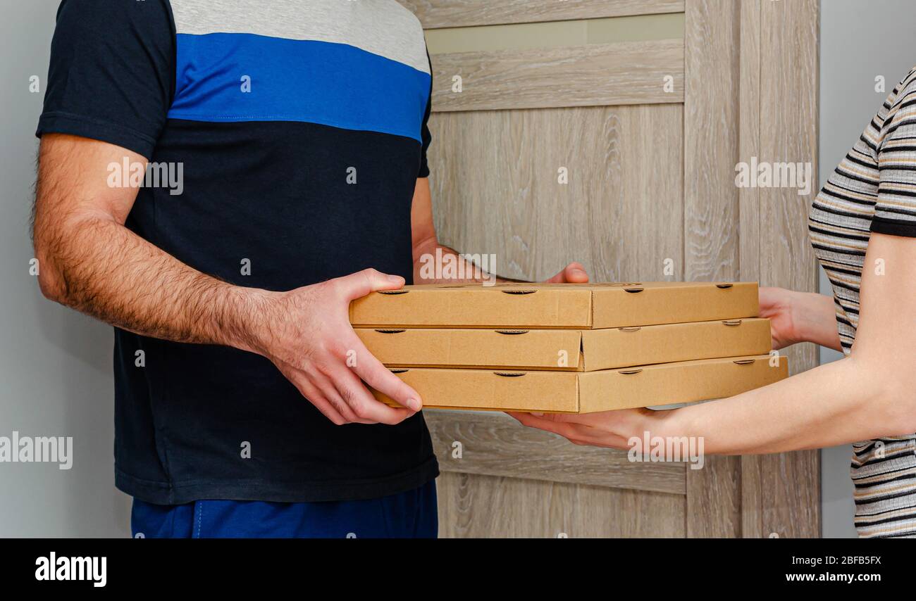 Uomo che consegna la pizza a casa di un cliente. Concetto di ordine alimentare. Foto Stock