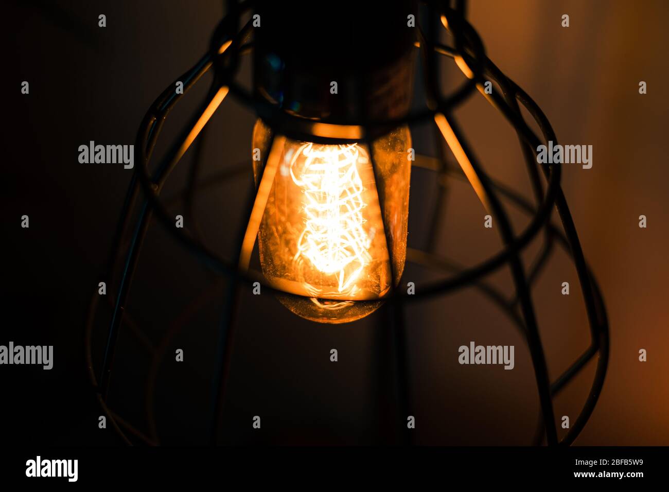 Lampadina ad incandescenza Vintage Edison in una lanterna rustica in metallo Foto Stock