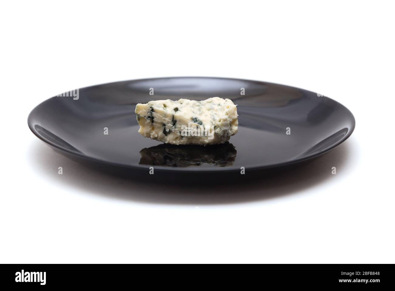 Pezzo di formaggio blu con stampo su piastra lucida nera isolata su fondo bianco Foto Stock