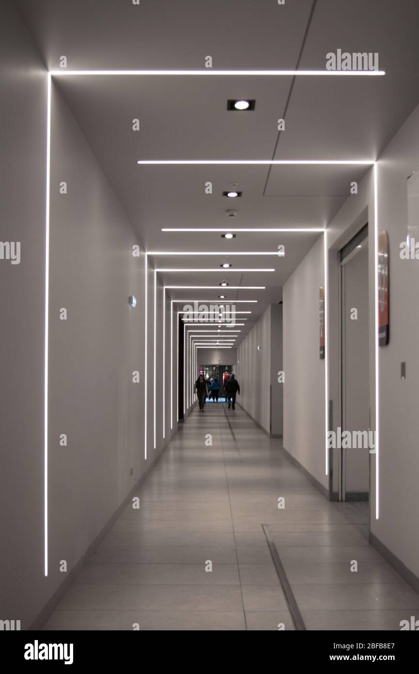 Un lungo e lungo passaggio in metropolitana con un interessante punto di forza geometrico, che forma un ritmo visivo. La gente sta camminando lungo esso. Tunnel, luce, infin Foto Stock