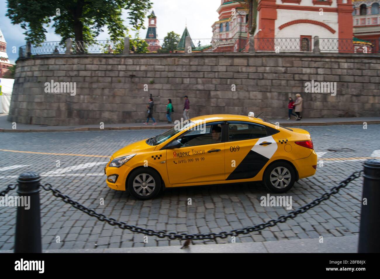 Mosca, Russia - Agosto 2019. Un taxi giallo Yandex attraversa il centro storico di Mosca lungo una strada lastricata di pietra. Antichità, architettura, v Foto Stock