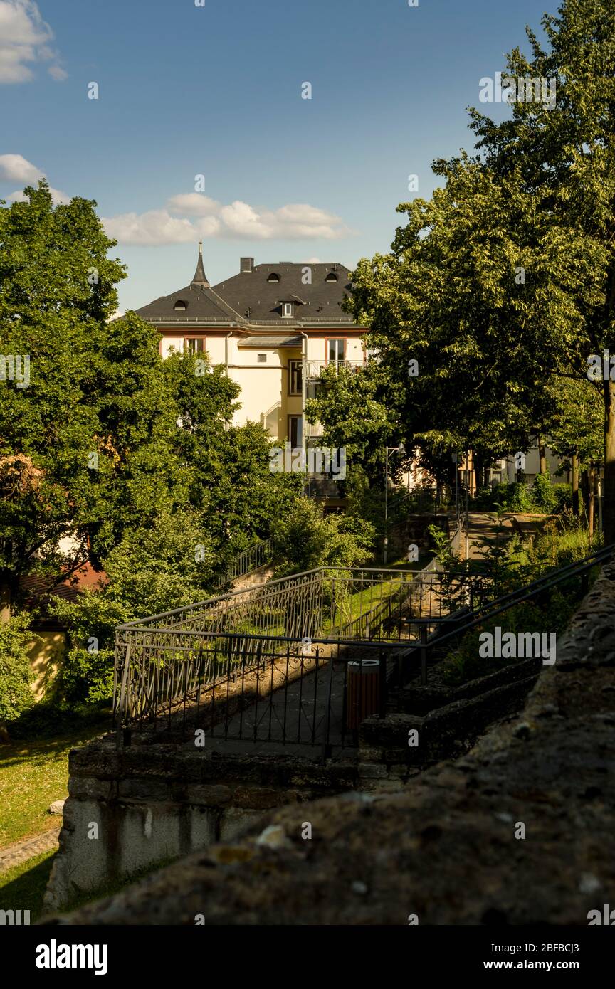 Villa in città al sole in un parco con molti alberi e mura della città vecchia Foto Stock