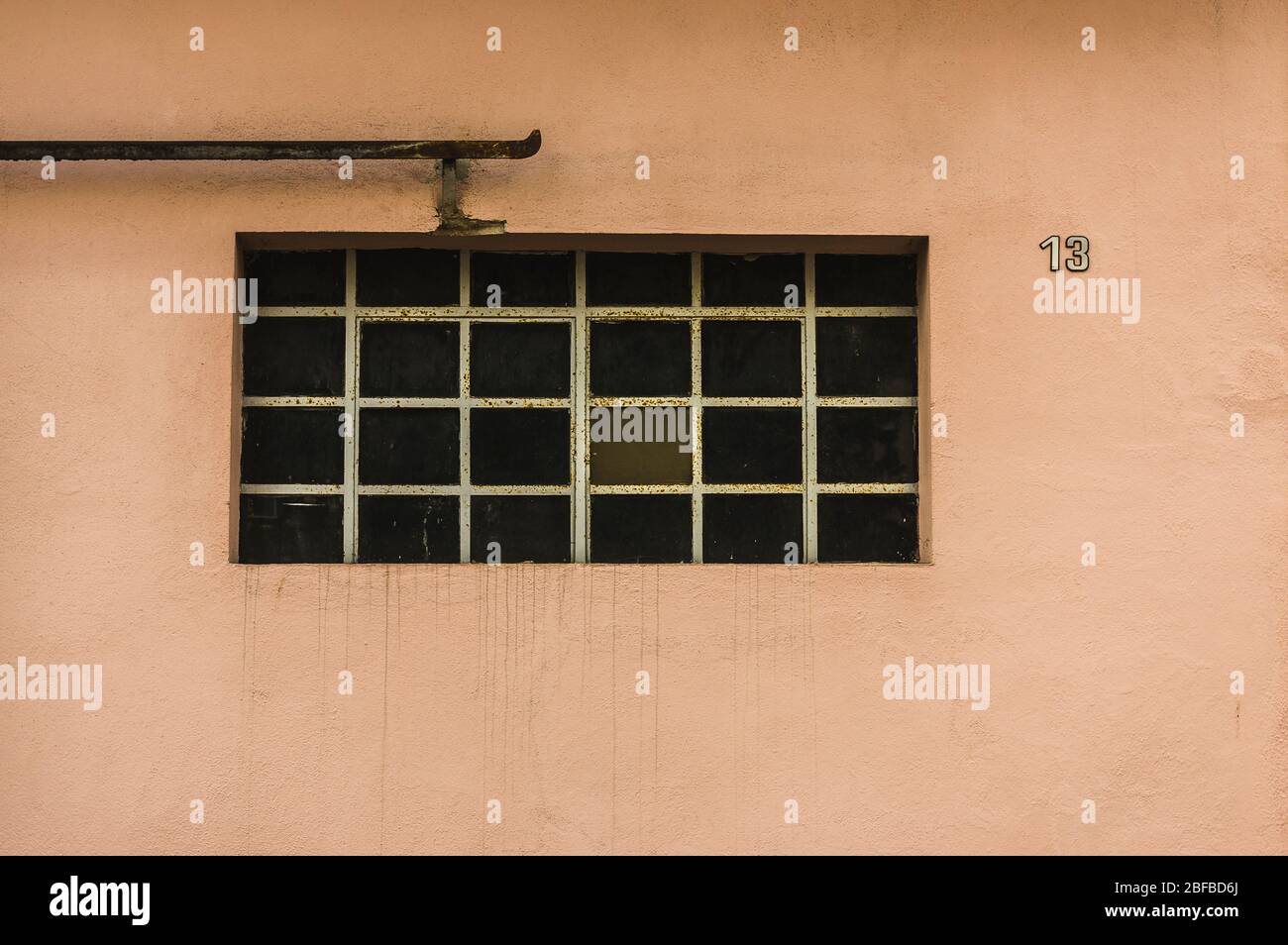 Facciata di un vecchio edificio con finestre in metallo e pioli Casa numero 13 porta di rotolamento bar Foto Stock