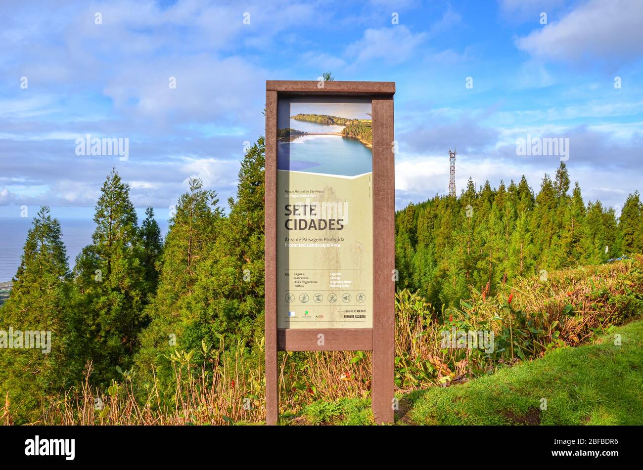 Sete Cidades, Azzorre, Portogallo - 12 gennaio 2020: Cartello informativo per i turisti a Sete Cidades. Cartello turistico in legno nell'area del paesaggio protetto portoghese. Verde foresta e oceano sullo sfondo. Foto Stock