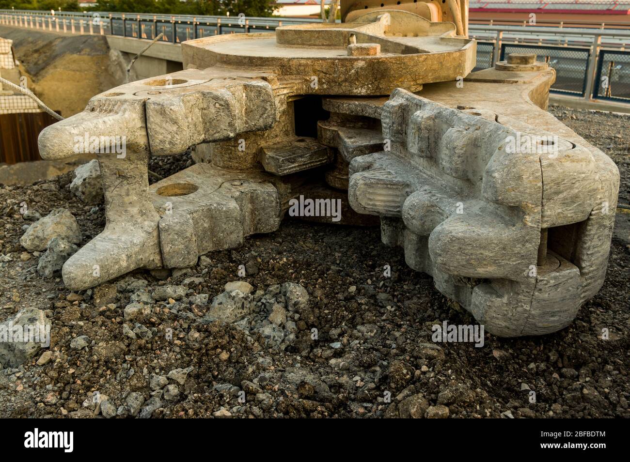 Attrezzi di attacco per escavatori come martello idraulico con scalpello e cesoie da demolizione, primo piano su un cantiere per la costruzione di strade e Foto Stock