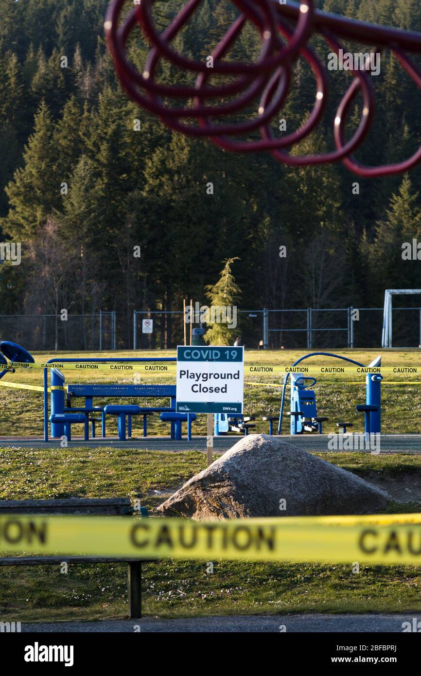 NORTH VANCOUVER, BC, CANADA - Apr 07, 2020: Un parco giochi chiuso in un parco pubblico North Vancouver fiancheggiato da nastro di attenzione per aiutare a limitare il Foto Stock
