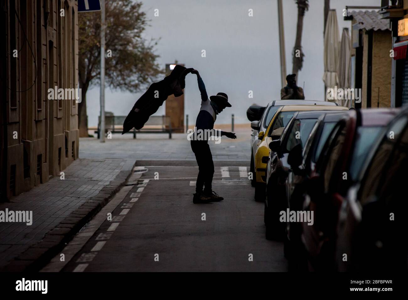 Barcellona, Catalogna, Spagna. 17 aprile 2020 - nel quartiere marittimo di la Barceloneta a Barcellona un uomo senza tetto reagisce come vicini dalla strada gioco bingo dai loro balconi. Il Ministero della Sanità spagnolo calcola un nuovo aumento dei decessi quotidiani per coronavirus, con 585 decessi registrati. Credit:Jordi Boixareu/Alamy Live News Foto Stock