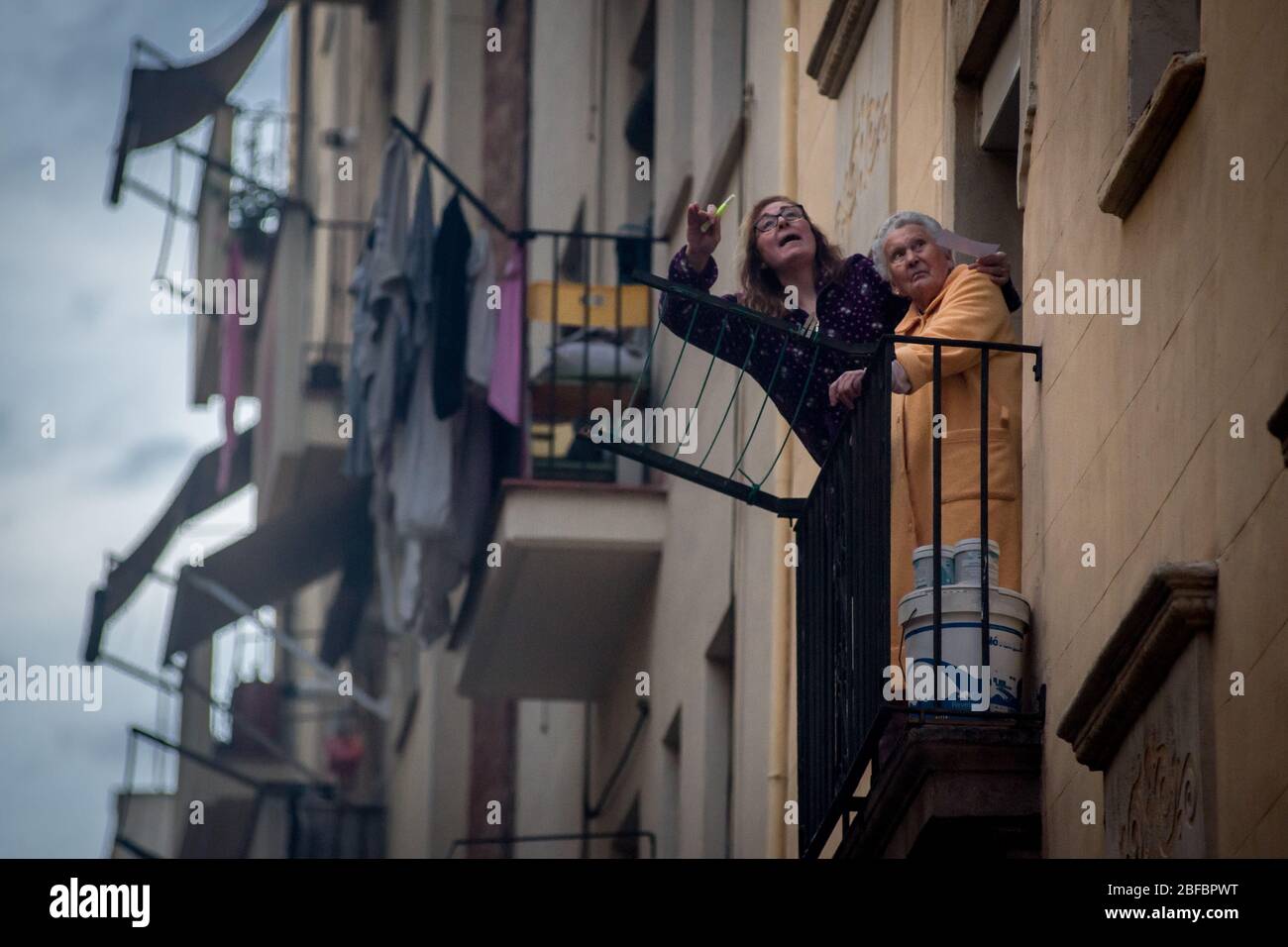 Barcellona, Catalogna, Spagna. 17 aprile 2020 - nel quartiere marittimo di la Barceloneta a Barcellona una donna e la sua madre anziana reagiscono come gioco bingo con altri vicini dal loro balcone. Il Ministero della Sanità spagnolo calcola un nuovo aumento dei decessi quotidiani per coronavirus, con 585 decessi registrati. Credit:Jordi Boixareu/Alamy Live News Foto Stock