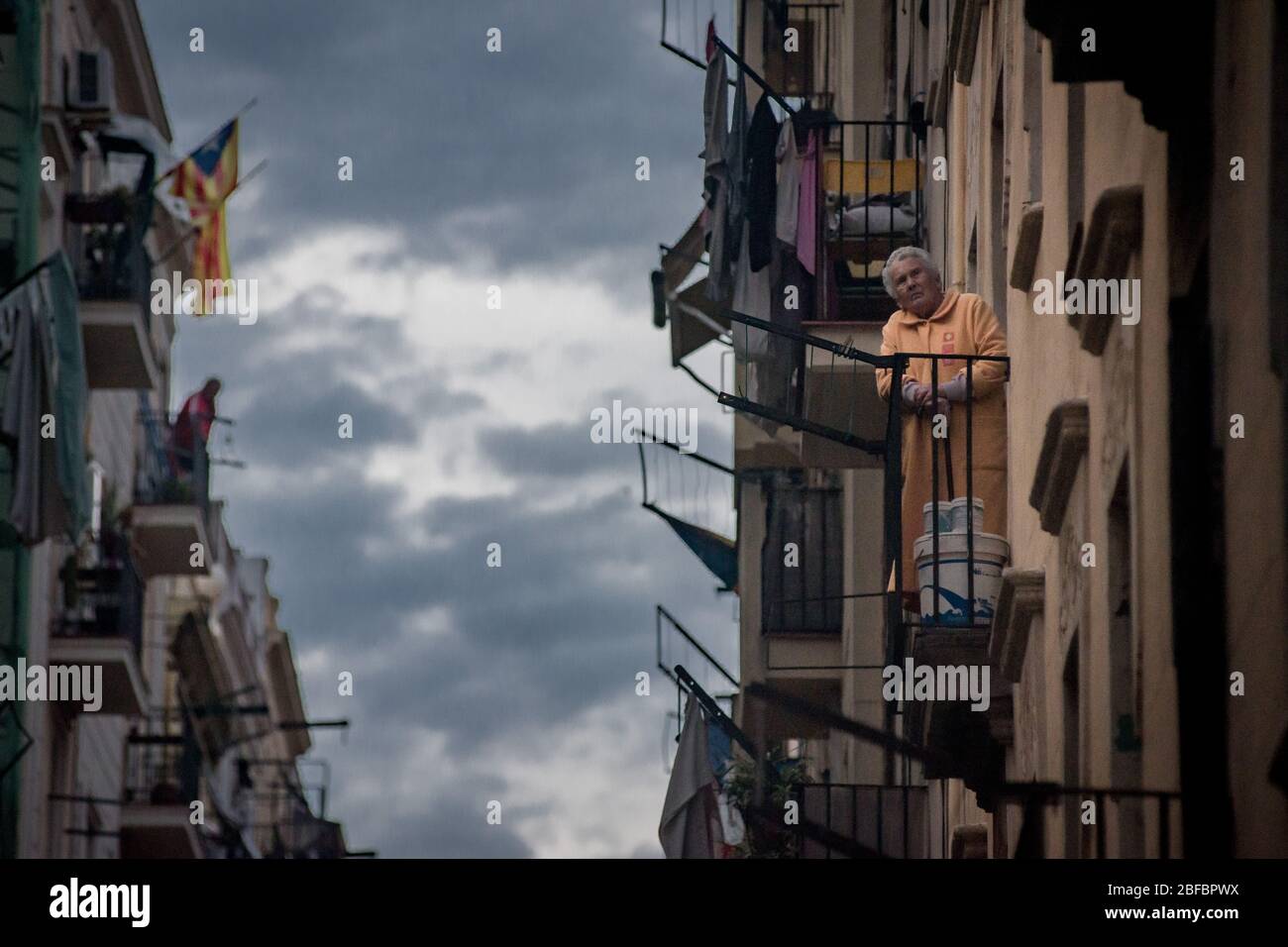 Barcellona, Catalogna, Spagna. 17 aprile 2020 - nel quartiere marittimo di la Barceloneta a Barcellona una donna anziana guarda sopra come i vicini giocano il bingo dai balconi. Il Ministero della Sanità spagnolo calcola un nuovo aumento dei decessi quotidiani per coronavirus, con 585 decessi registrati. Credit:Jordi Boixareu/Alamy Live News Foto Stock