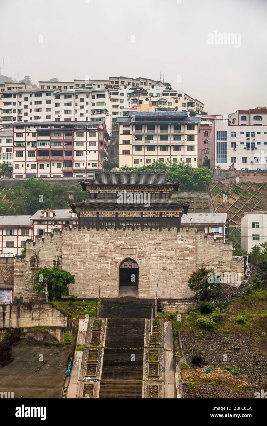 Baidicheng, Cina - 7 maggio 2010: Gola di Qutang sul fiume Yangtze. Ritratto della storica porta cittadina e alto edificio sotto nebbia bianca sulle colline. Lunga Foto Stock