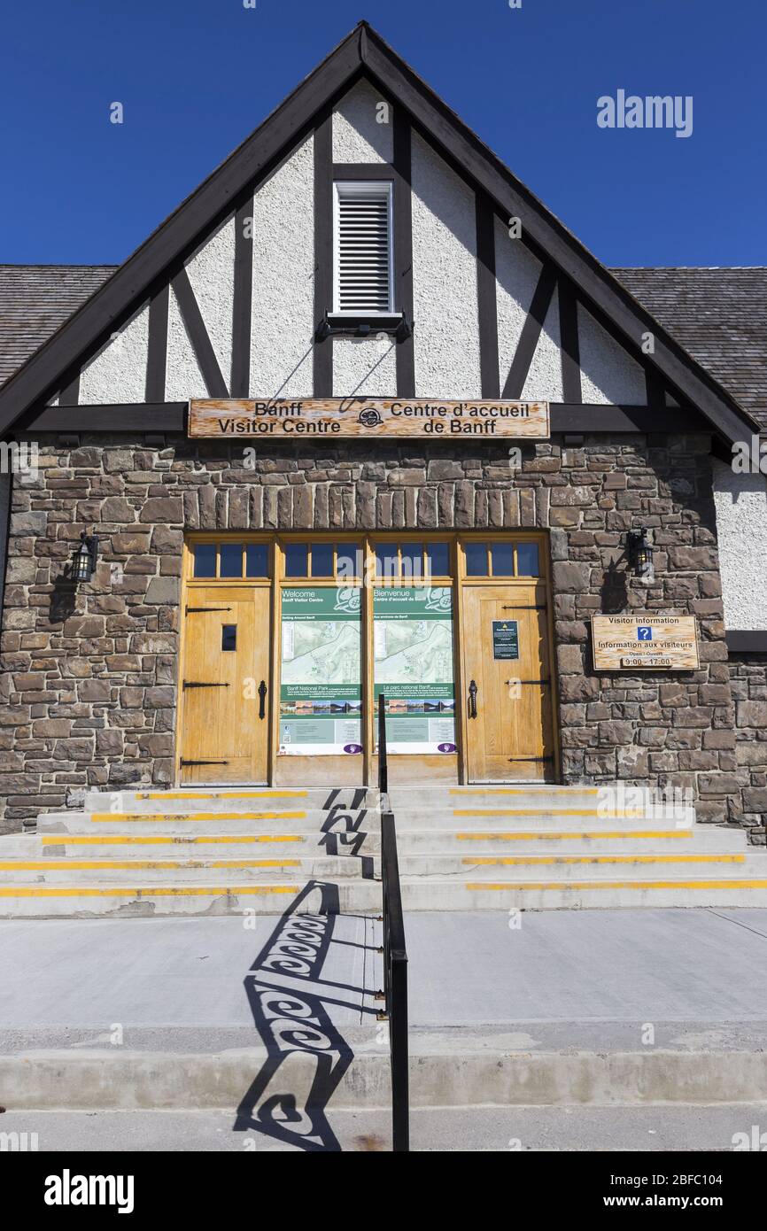 Parks Canada Banff Visitor Centre Main Street Building entrata chiusa. Facciata architettura esterno verticale Ritratto con ringhiera e cielo blu Foto Stock