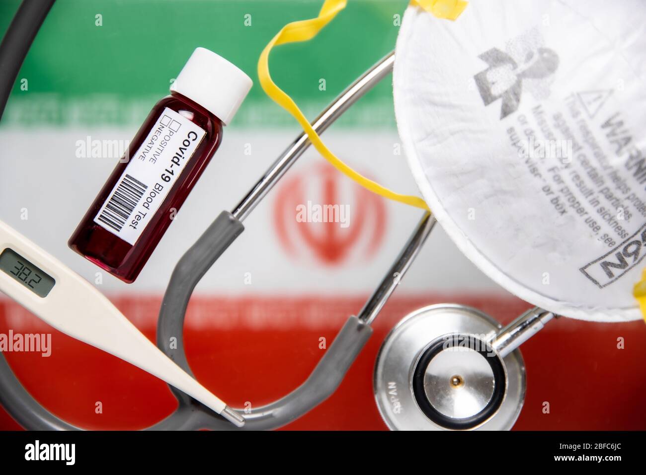 Concetto di Coronavirus o Covid-19 pandemic da usare come sfondo con bandiera iraniana paese e esame del sangue medico, stetoscopio, maschera chirurgica N95 Foto Stock