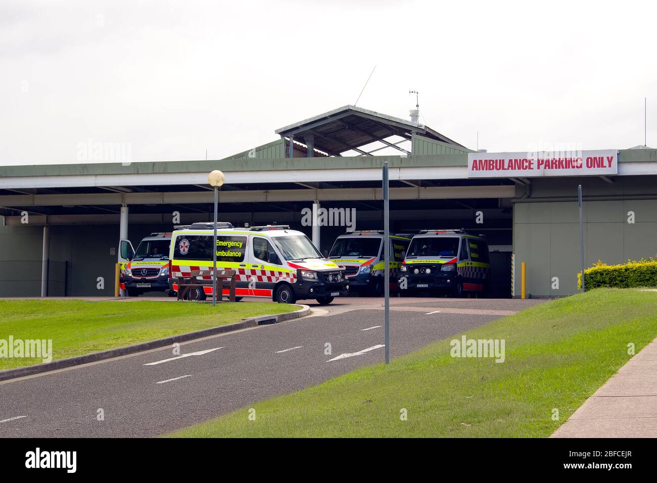 L'ambulanza lascia la linea di parcheggio dell'ospedale, rispondendo a una chiamata Foto Stock