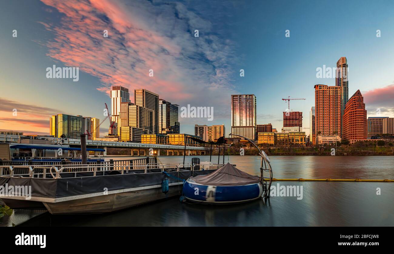 Panorama con gli alti alti alti alti del centro che riflettono il tramonto luce d'ora dorata vista attraverso Lady Bird Lake o Town Lake sul fiume Colorado a Austin, Texas USA Foto Stock