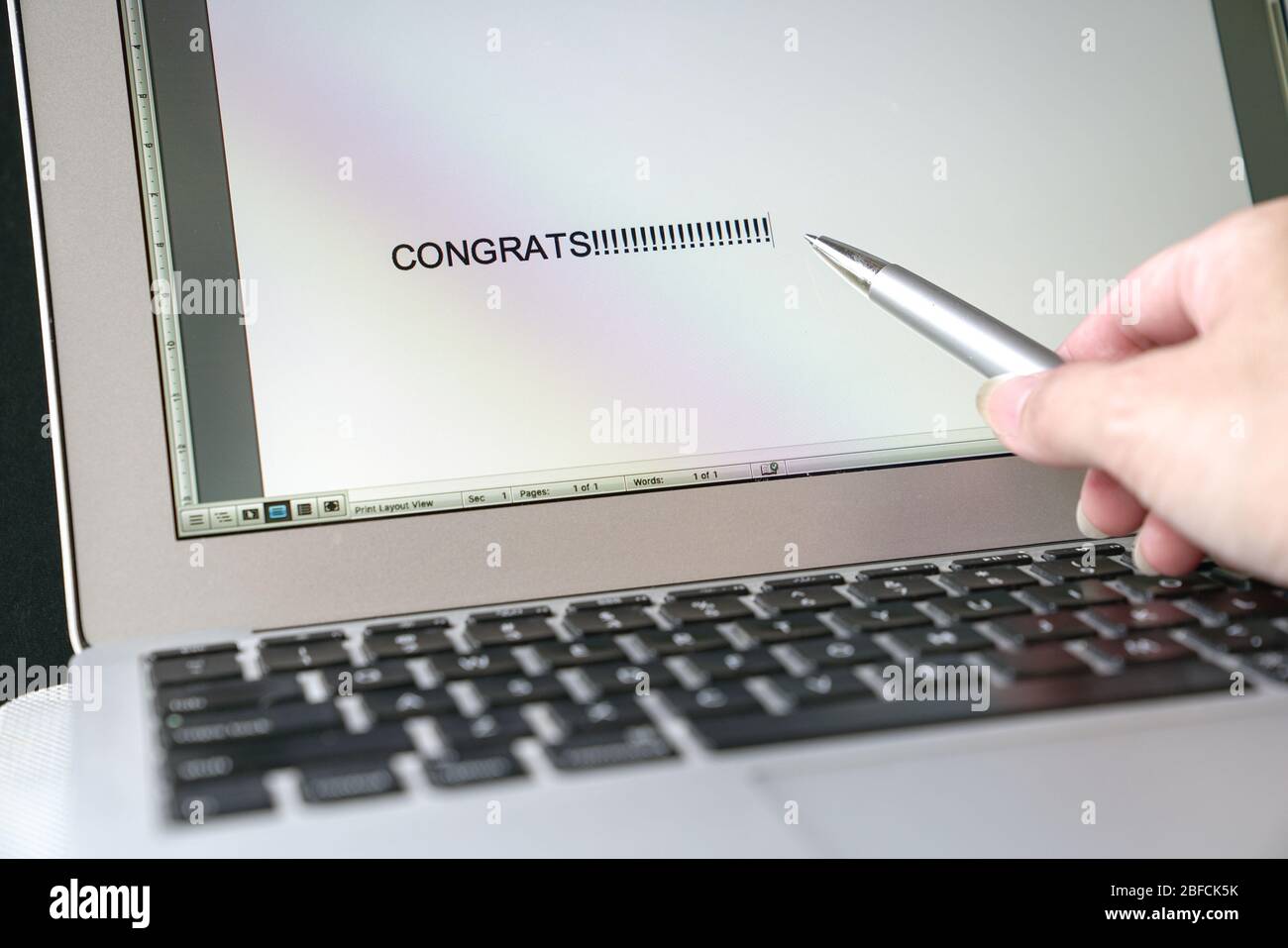 Penna puntata sulla parola digitata, "Congrats" (Congrats) che appaiono sullo schermo del computer Foto Stock
