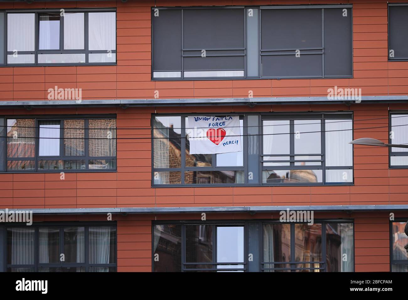 Bruxelles. 17 Aprile 2020. La foto del 17 aprile 2020 mostra una bandiera che porta "l'unità è la forza" su una finestra di un edificio a Bruxelles, Belgio. È trascorso un mese da quando il Belgio ha adottato misure di blocco per contenere la diffusione di nuovi coronavirus il 18 marzo. Il primo ministro belga Sophie Wilmes ha annunciato il 15 aprile una proroga del blocco fino al 3 maggio. Credit: Zhang Cheng/Xinhua/Alamy Live News Foto Stock