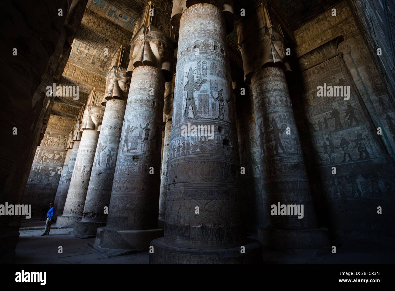 Un turista si trova sotto le colonne all'interno del Tempio di Hathor a Dendera vicino Luxor, Egitto. Foto Stock