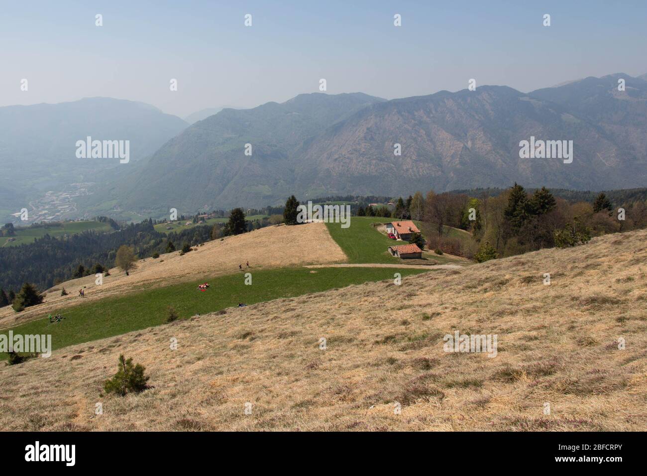 La vista del contryside rurale in montagna. Campi agricoli su colline con montagne sullo sfondo. Foto Stock