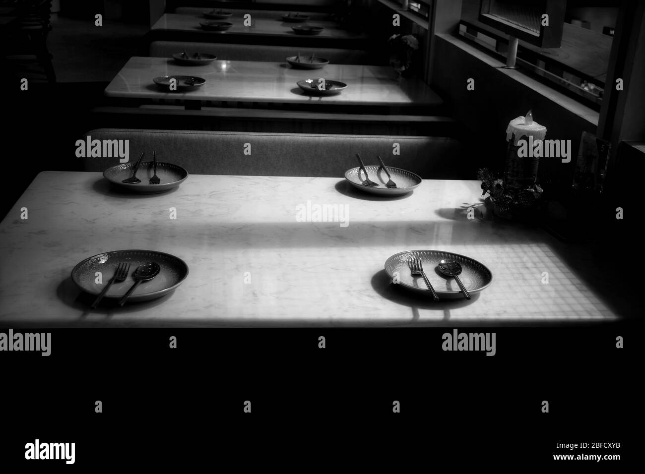 Piatti vuoti e tavolo in un ristorante mostra la solitudine, crisi economica e depressione causata da distensione sociale, blocco e auto iso Foto Stock