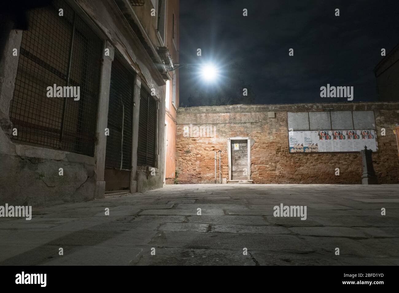 Una vista notturna di una strada vuota a Venezia, Italia Foto Stock