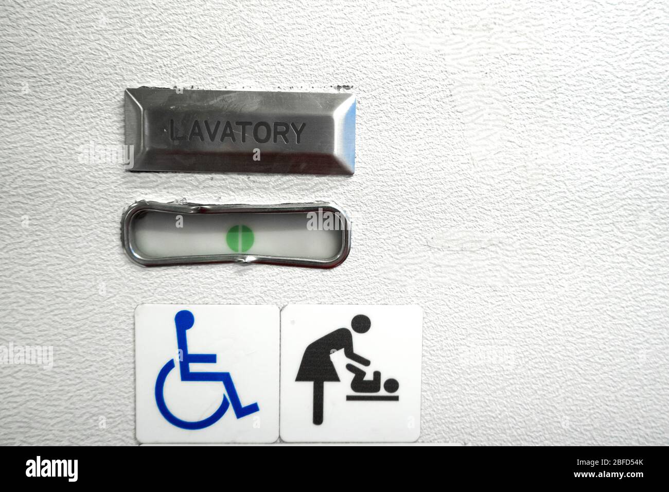 Un cartello nel bagno di un aereo, il che significa che il bagno è  attrezzato per disabili. E ha una tabella cambiante Foto stock - Alamy