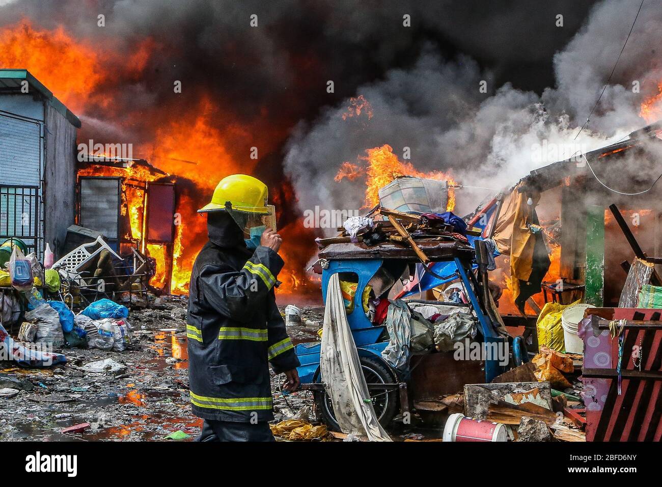 Manila, Filippine. 18 Aprile 2020. Un vigile del fuoco è visto da un incendio che inghiotte una zona di baraccopoli a Manila, Filippine, 18 aprile 2020. Centinaia di famiglie qui sono state sfollate sabato a causa del fuoco. Credit: Rouelle Umali/Xinhua/Alamy Live News Foto Stock