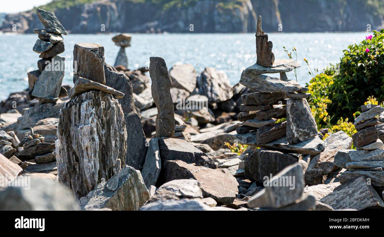 Rocce impilate l'una sull'altra in un giardino di roccia artificiale su Peaks Island con acqua sullo sfondo nel Maine USA. Foto Stock