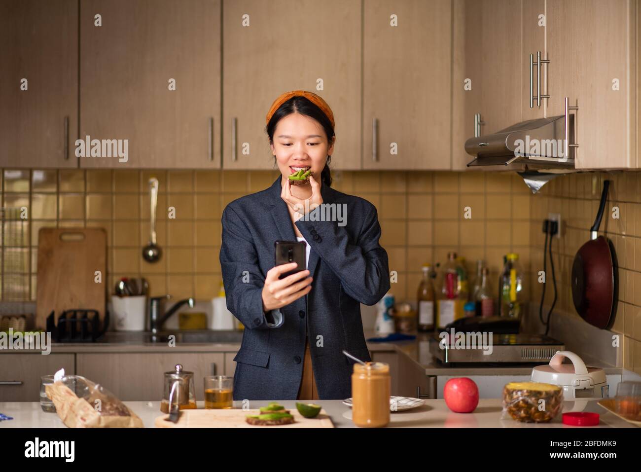 Allegra donna asiatica che si fida in cucina dopo aver trascorso troppo tempo all'interno Foto Stock