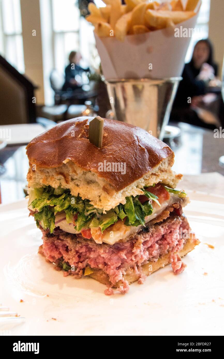 CHICAGO, ILLINOIS, STATI UNITI - DEC 12, 2015: Cheeseburger gourmet con patatine fritte in background in un ristorante di lusso Foto Stock