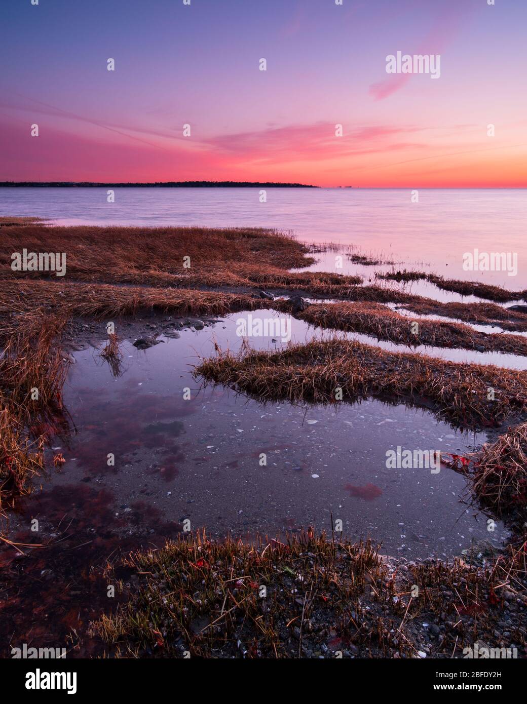 Un cielo crepuscolo si illumina di colore sulle acque calme di Long Island Sound (Greenwich Point Park, Greenwich, Connecticut). Foto Stock