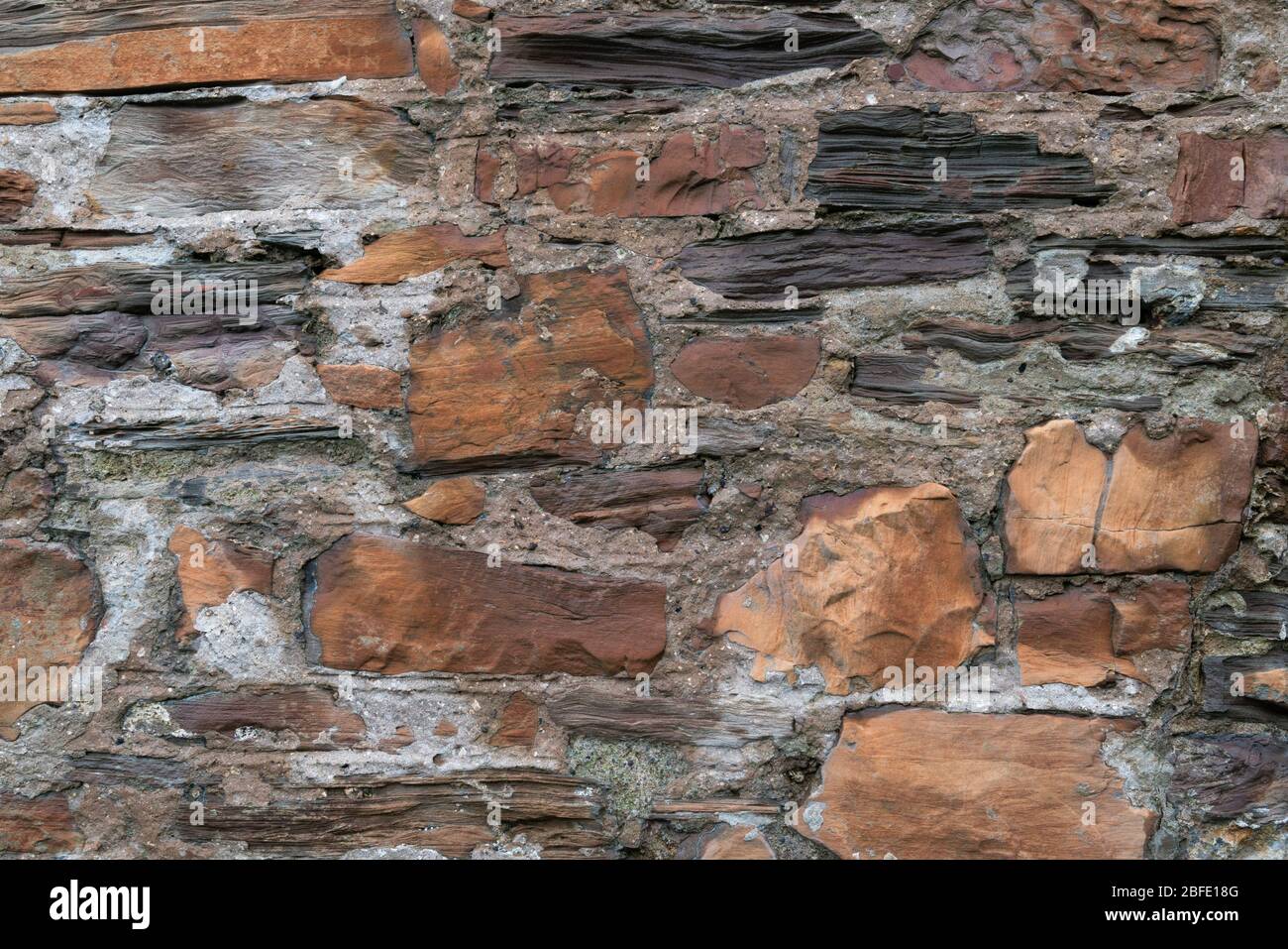 Vista dettagliata di mattoni vecchi e ruvidi esposti e di muri in pietra Foto Stock