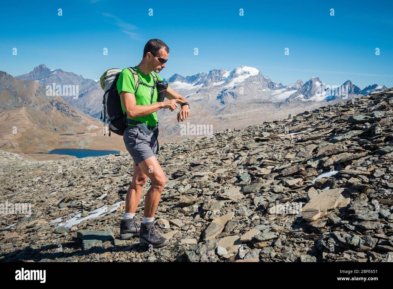 Alpinista che orienta nelle Alpi in una bella giornata di sole Foto Stock