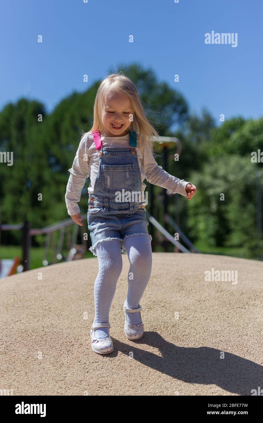 Ritratto di felice bionda 4 anni ragazza che gioca sul parco giochi Foto Stock