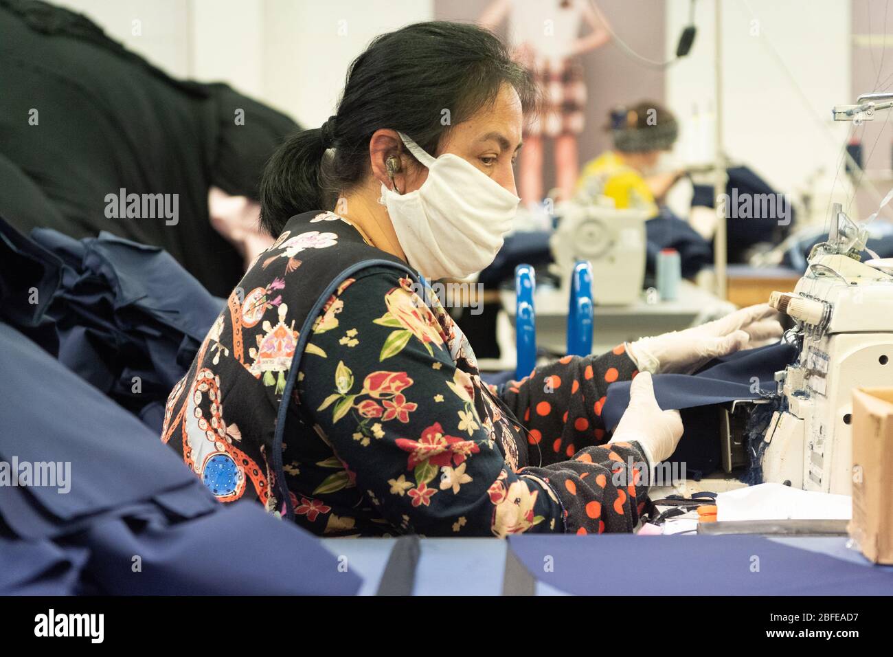 Un machinista cucire abbigliamento medico per il NHS (National Health Service) presso la fabbrica di Fashion-Enter Ltd. Foto Stock