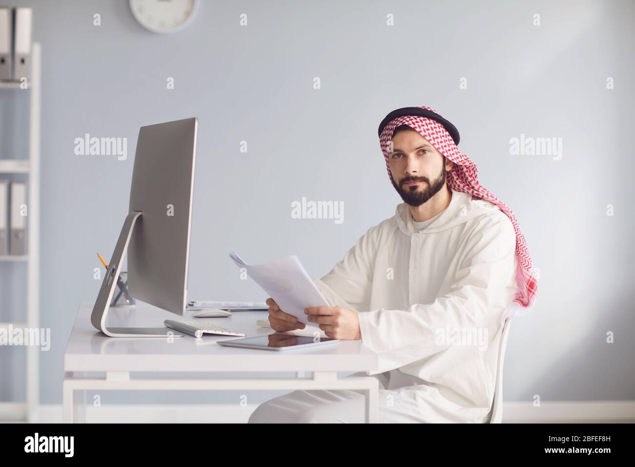 L'uomo d'affari arabo lavora in computer sul posto di lavoro in ufficio. Foto Stock
