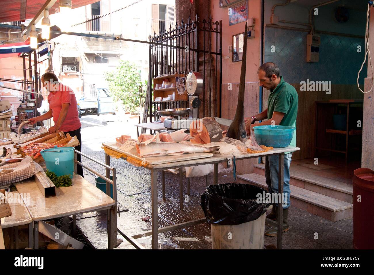 Palermo, Sicilia, Italia - 14 settembre 2014: Mercato del pesce tradizionale, un uomo che taglia il tonno Foto Stock