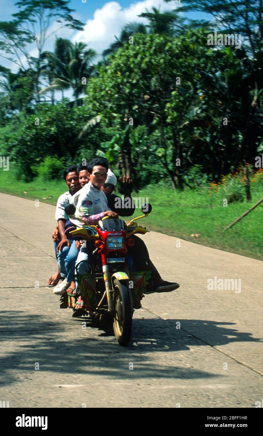 Quattro persone in un ciclo di motocicci, Mindanao, Filippine, marzo 1996 Foto Stock