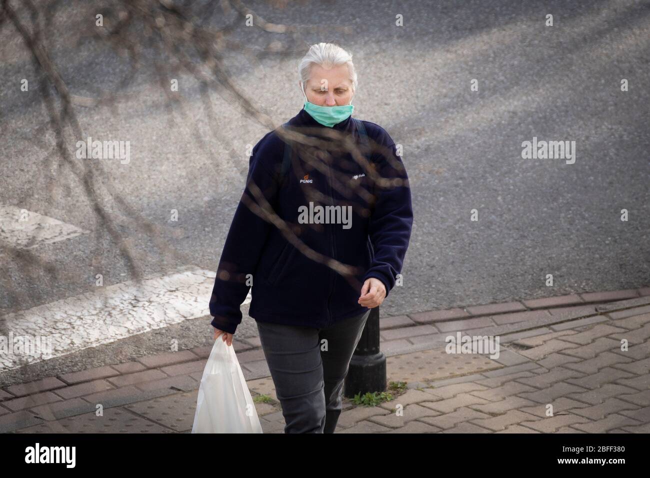 Varsavia. 18 Aprile 2020. Una donna è vista indossare maschera facciale a Varsavia, Polonia il 18 aprile 2020. La Polonia ha definito quattro fasi in cui le restrizioni saranno gradualmente abolite, a partire dall’apertura di parchi e foreste e fino ai servizi che richiedono contatti fisici. Credit: Jaap Arriens/Xinhua/Alamy Live News Foto Stock