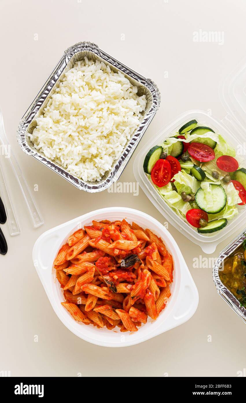 Cibo da asporto in contenitori usa e getta: Riso, curry vegetale, pasta  italiana con salsa di pomodoro e insalata fresca e salutare Foto stock -  Alamy