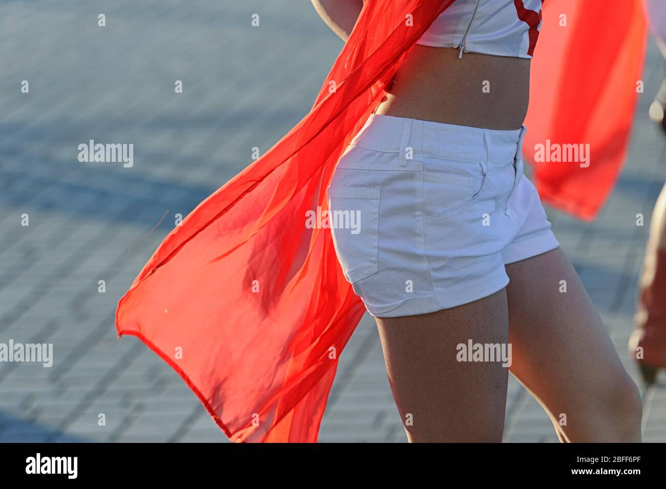 Una giovane ragazza asiatica che indossa pantaloni caldi e porta un banner rosso alla Calgary Stampede Parade. Alberta Canada Foto Stock