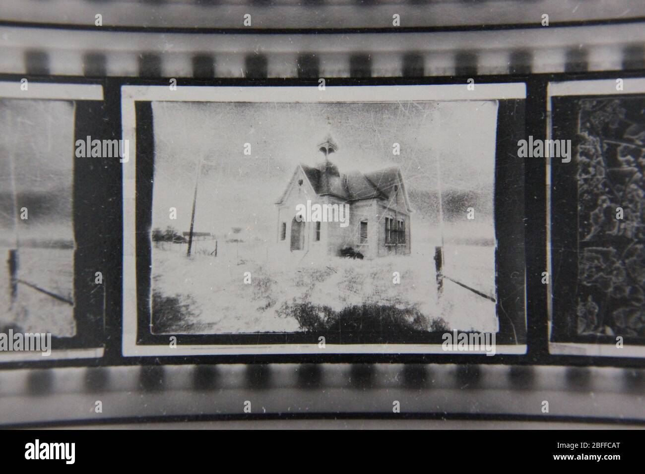Fine anni '70 estremo contrasto contatto stampa fotografia di una casa di scuola spettrale seduta su una collina Foto Stock