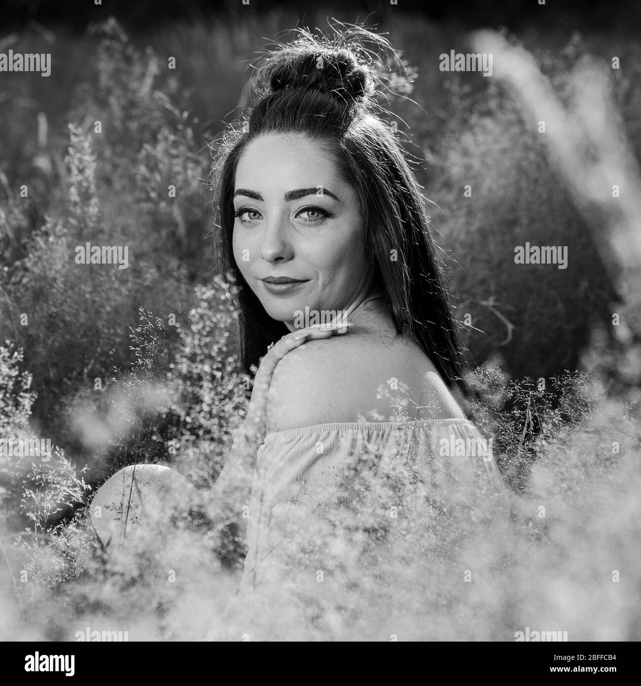 Un raccolto di quadrati ritratto di un mio amico circondato da luminose erba selvatica nelle vicinanze del Liverpool. Foto Stock