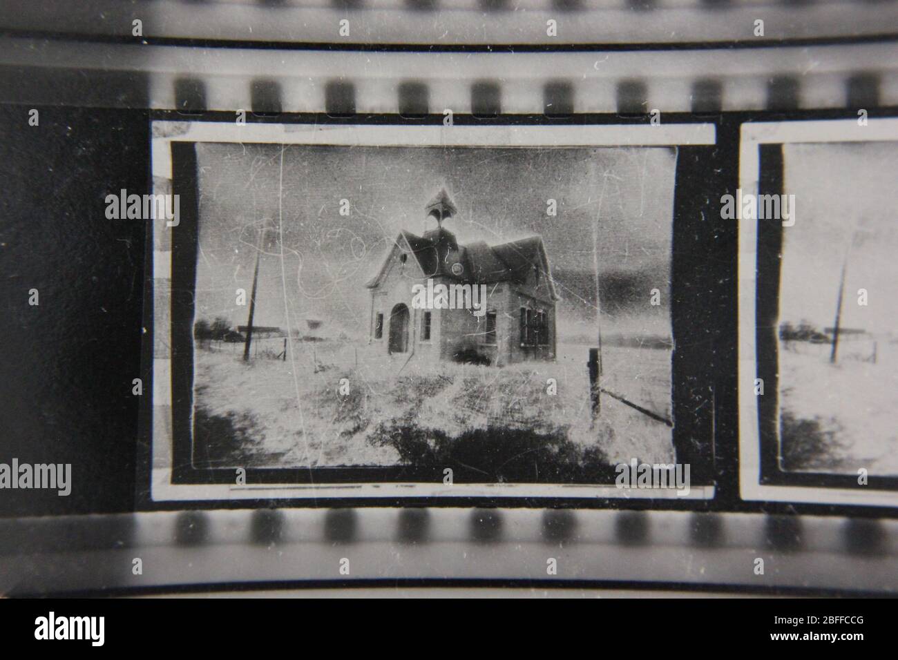 Fine anni '70 estremo contrasto contatto stampa fotografia di una casa di scuola spettrale seduta su una collina Foto Stock