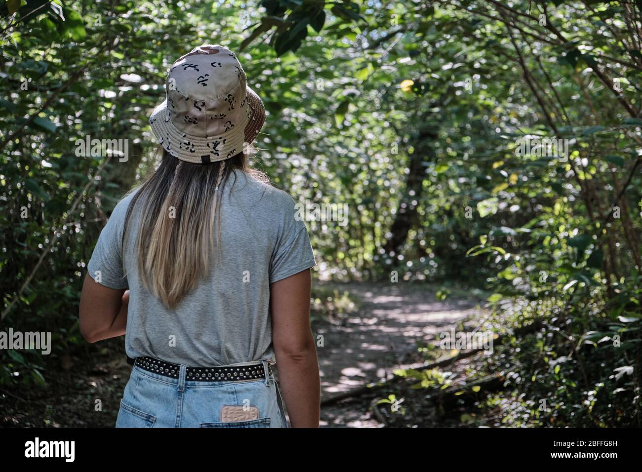 una bella donna modello bere yerba mate infusione mentre si cammina attraverso gli alberi Foto Stock