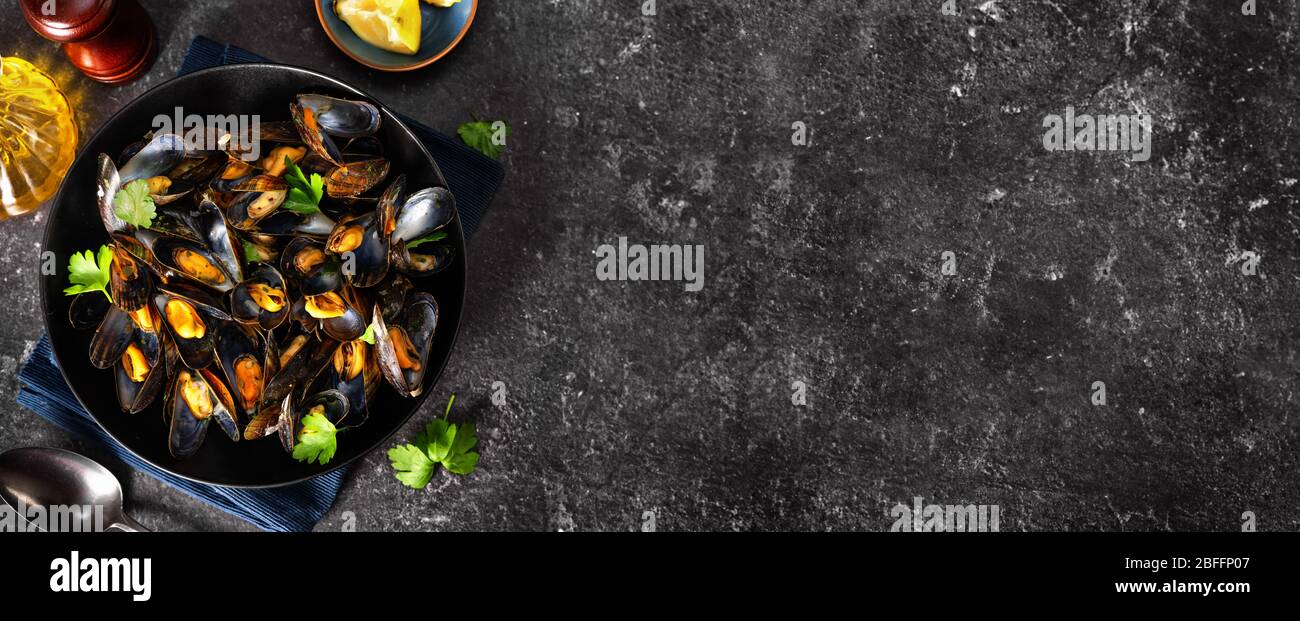 Primo piano di un piatto con cozze al vapore su nero sfondo Foto Stock