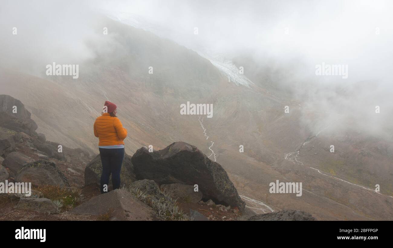 Cayambe, Pichincha / Ecuador - Febbraio 24 2020: Giovane donna sola guardando il paesaggio del vulcano Cayambe vicino al rifugio Ruales Oleas Berge Foto Stock