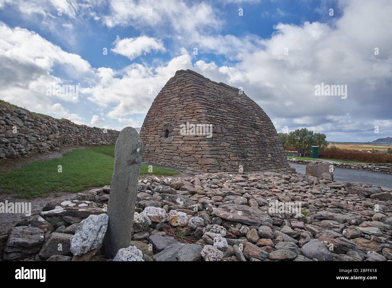 Vista esterna sul Gallarus Oratory nella contea di Dingle Peninsula Kerry Irlanda mostrando la pietra di Colum Mac Dinet in primo piano. Foto Stock